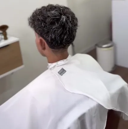 Pelo rizado con mechas blancas arriba y los lados cortos, visto de espaldas