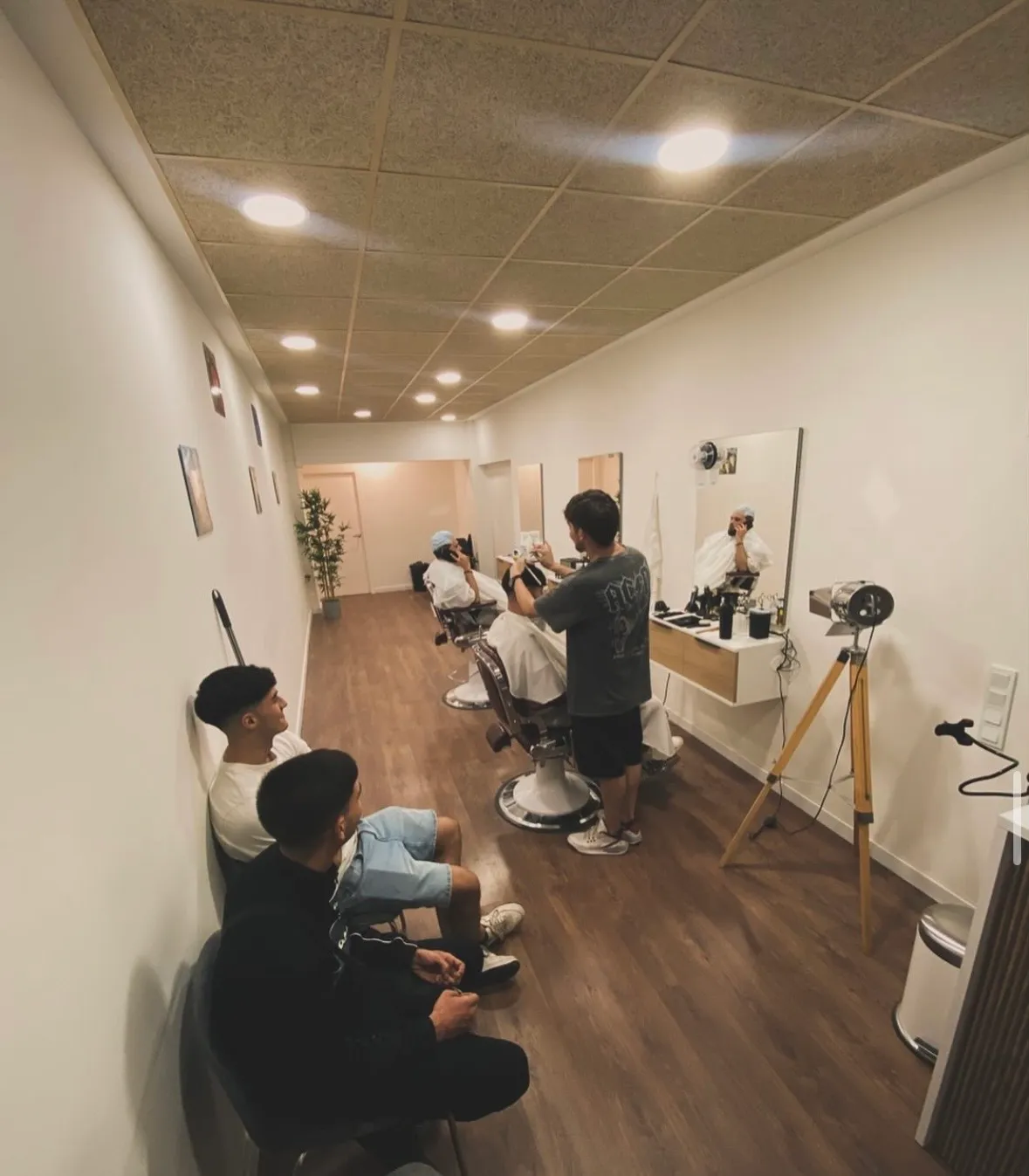 El barbero cortando el pelo a un cliente en el local de Barbería Zapata