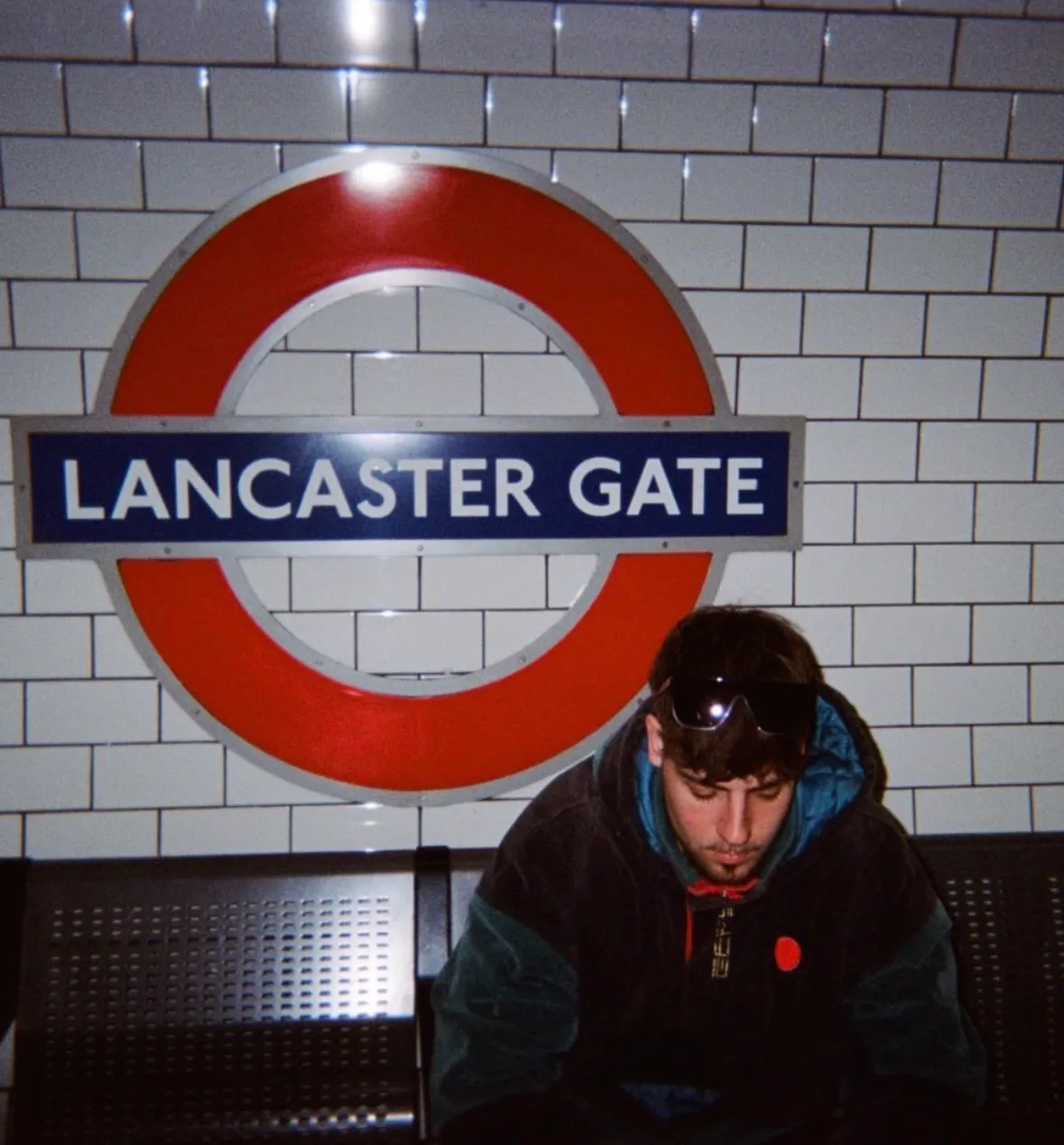 Xavier Zapata Cantalejos sentado en un andén del metro de Londres, bajo el cartel de Lancaster Gate